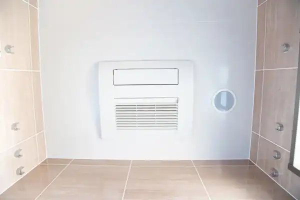 Ceiling view of a modern shower with multiple wall-mounted jets, tan tiles, and a white ventilation unit—perfect for homes in White Plains NY considering dehumidifier installation to maintain fresh, dry air.